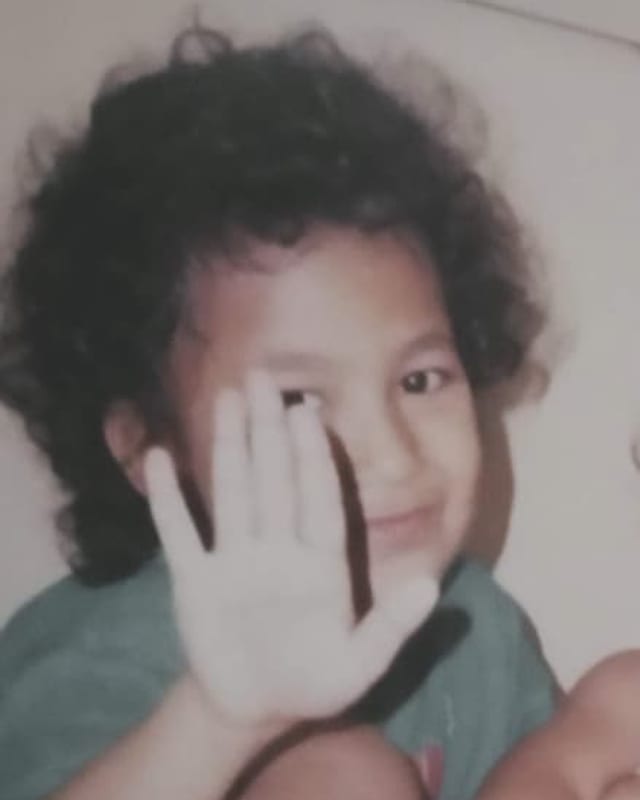 Yoan Letsoin as a child, waving at the camera
